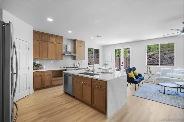 a kitchen with stainless steel appliances kitchen island a table and chairs in it