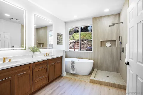 a bathroom with a tub a sink and a large mirror