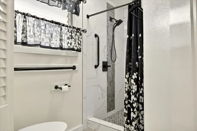 a bathroom with a shower toilet and sink