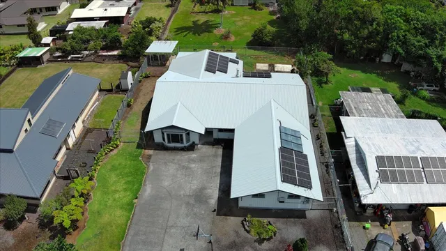an aerial view of a house with swimming pool and large trees