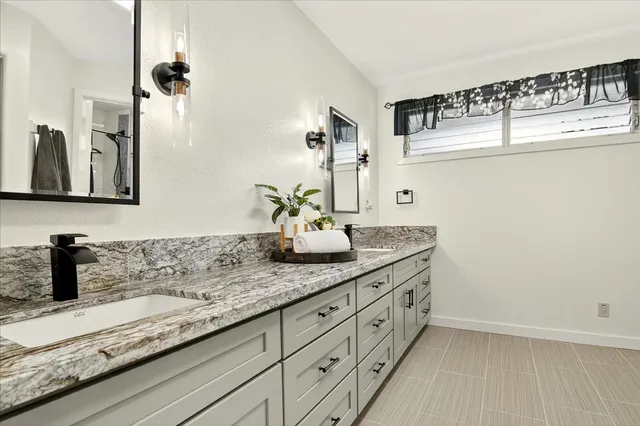 a bathroom with a granite countertop sink and a mirror