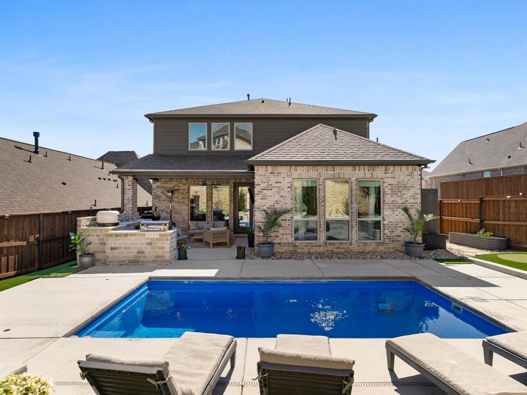 112 Pecan Court Rhome, TX 76078 - Photo 34 of 38 Rear view of property featuring an outdoor kitchen and area to lounge, a patio area, a fenced backyard, and brick siding