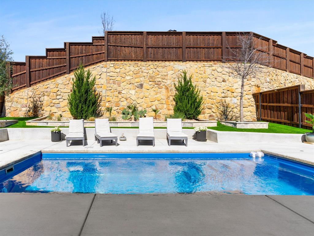 112 Pecan Court Rhome, TX 76078 - Photo 35 of 38 Resort-style backyard featuring a stunning sparkling swimming pool, creating the perfect outdoor retreat at this beautiful home in Rhome, Texas.