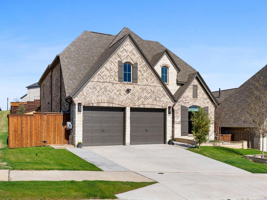 112 Pecan Court Rhome, TX 76078 - Photo 5 of 38 French provincial home featuring brick siding, driveway, roof with shingles, and stone siding