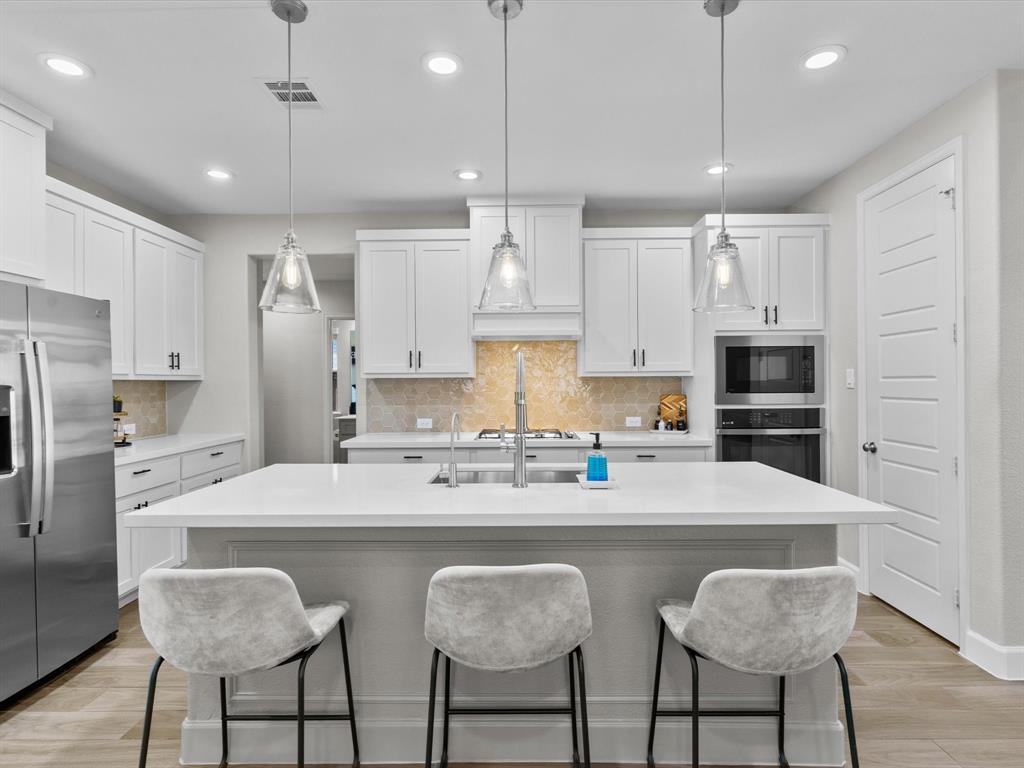 112 Pecan Court Rhome, TX 76078 - Photo 9 of 38 Large kitchen island perfect for meal prep, casual dining, or gathering with family and friends.