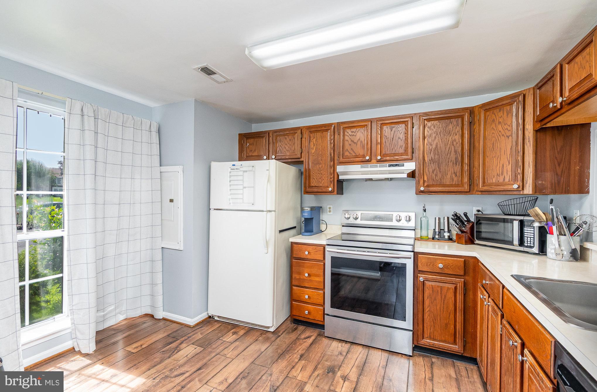1213 Brice Square Belcamp, MD 21017 - Photo 10 of 23 a kitchen with a refrigerator stove and wooden cabinets