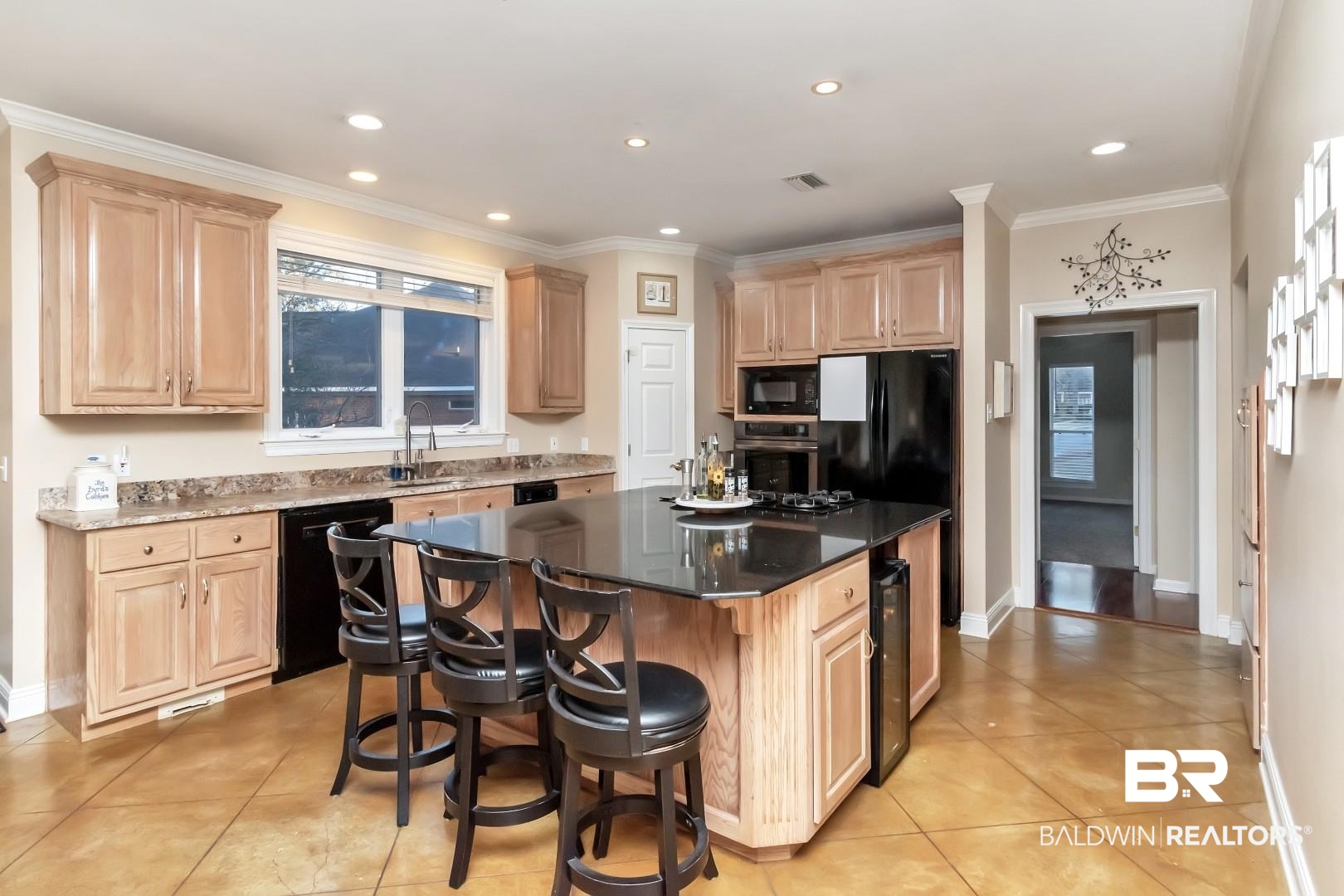 1050 Southern Way Court Mobile, AL 36609 - Photo 9 of 36 Kitchen with light brown cabinetry, a center island, a breakfast bar area, and black appliances