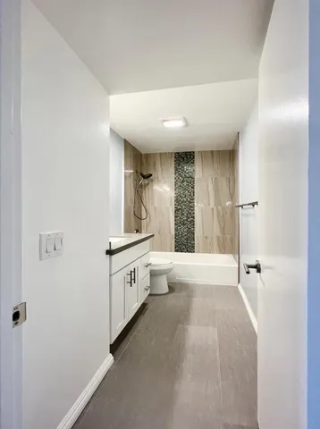 a large white kitchen with a granite countertop sink