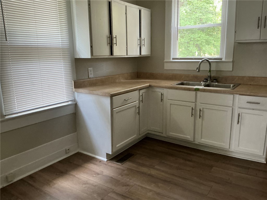 504 Caughlin Avenue Anderson, SC 29624 - Photo 5 of 15 A well-lit kitchen with ample cabinetry and a practical double-basin sink, offering a functional culinary space.
