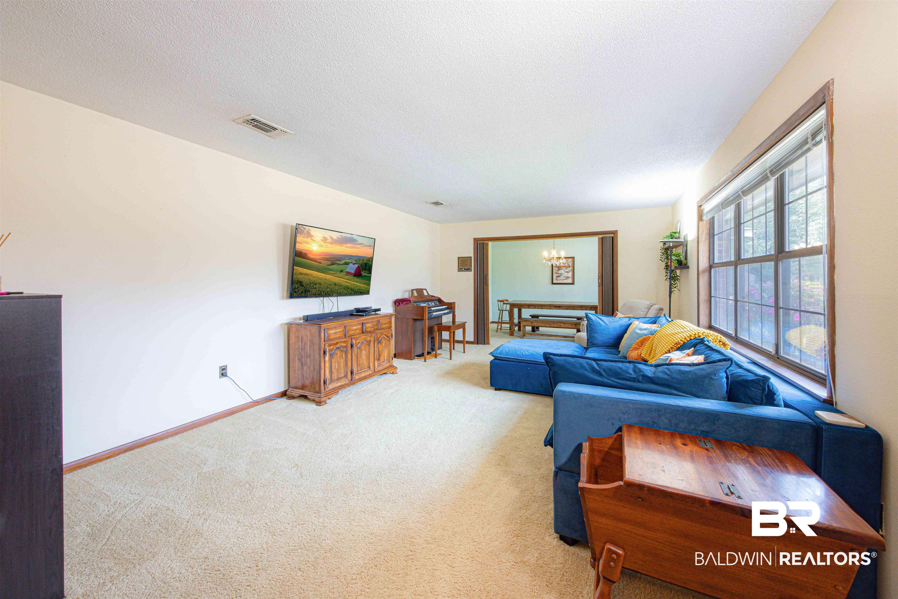 47580 Rabun Road Bay Minette, AL 36507 - Photo 6 of 55 Living area with visible vents, baseboards, a textured ceiling, light colored carpet, and a chandelier