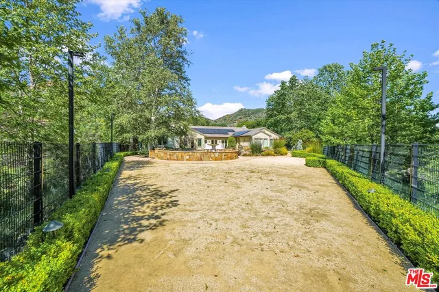 an aerial view of residential house with outdoor space and trees all around
