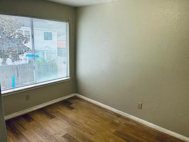 a view of a small space with wooden floor and a window