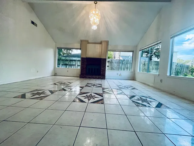 a very nice looking living room with a large window and chandelier