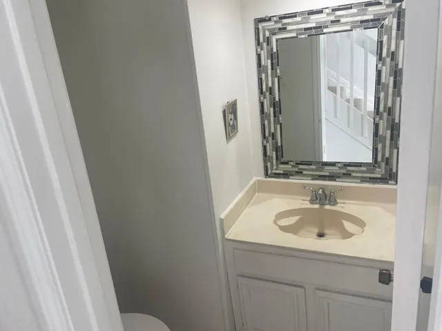 a bathroom with a sink and mirror with toilet