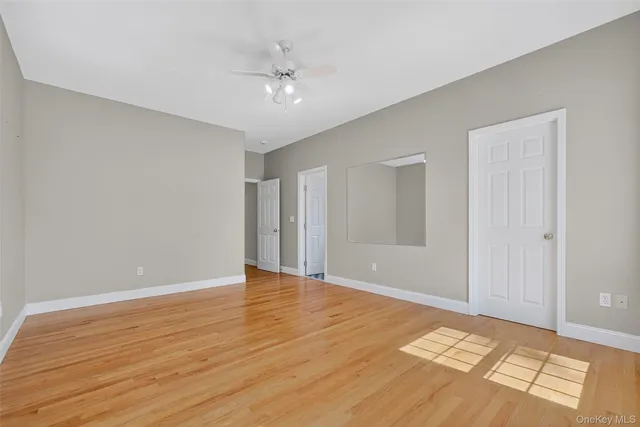 a view of an empty room and window and wooden floor
