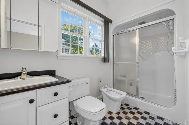 a bathroom with a granite countertop sink toilet a mirror and shower