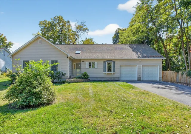 a front view of a house with a garden and yard
