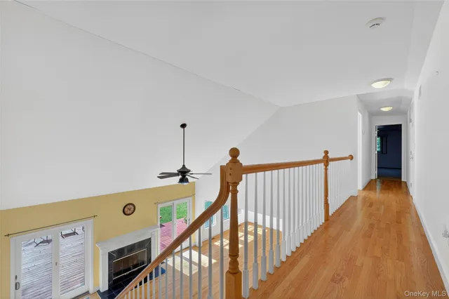 a view of a hallway with wooden floor and staircase