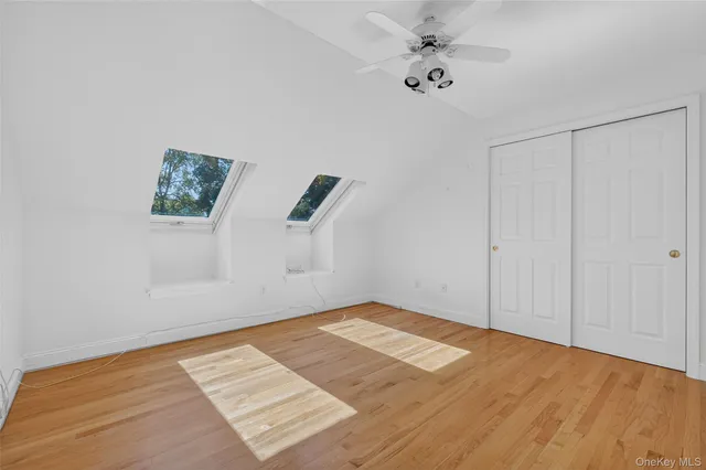 an empty room with a ceiling fan and window