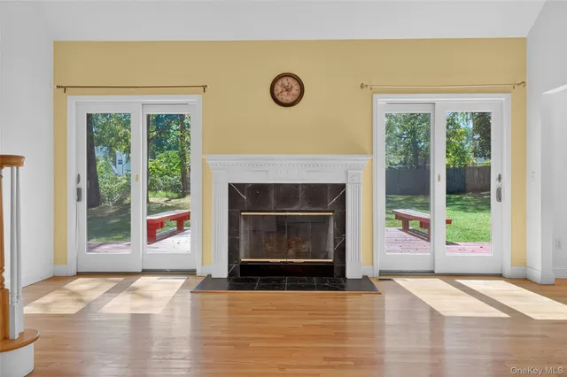 a view of empty room with wooden floor and fireplace