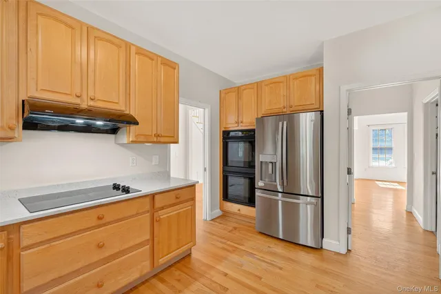a kitchen with stainless steel appliances granite countertop a refrigerator microwave and cabinets