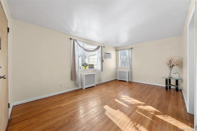 a view of empty room with wooden floor and window
