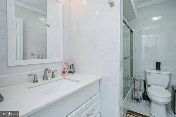 a bathroom with a sink toilet vanity and shower