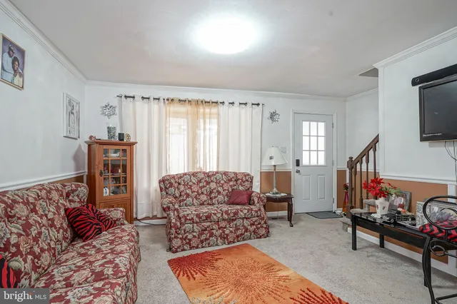 a living room with furniture a rug and a flat screen tv