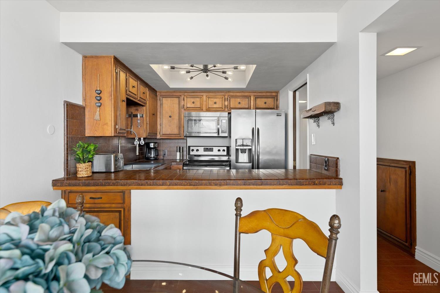Undisclosed Address Bakersfield, CA 93306 - Photo 22 of 52 a kitchen with stainless steel appliances granite countertop a stove a sink and a dining table with wooden floor