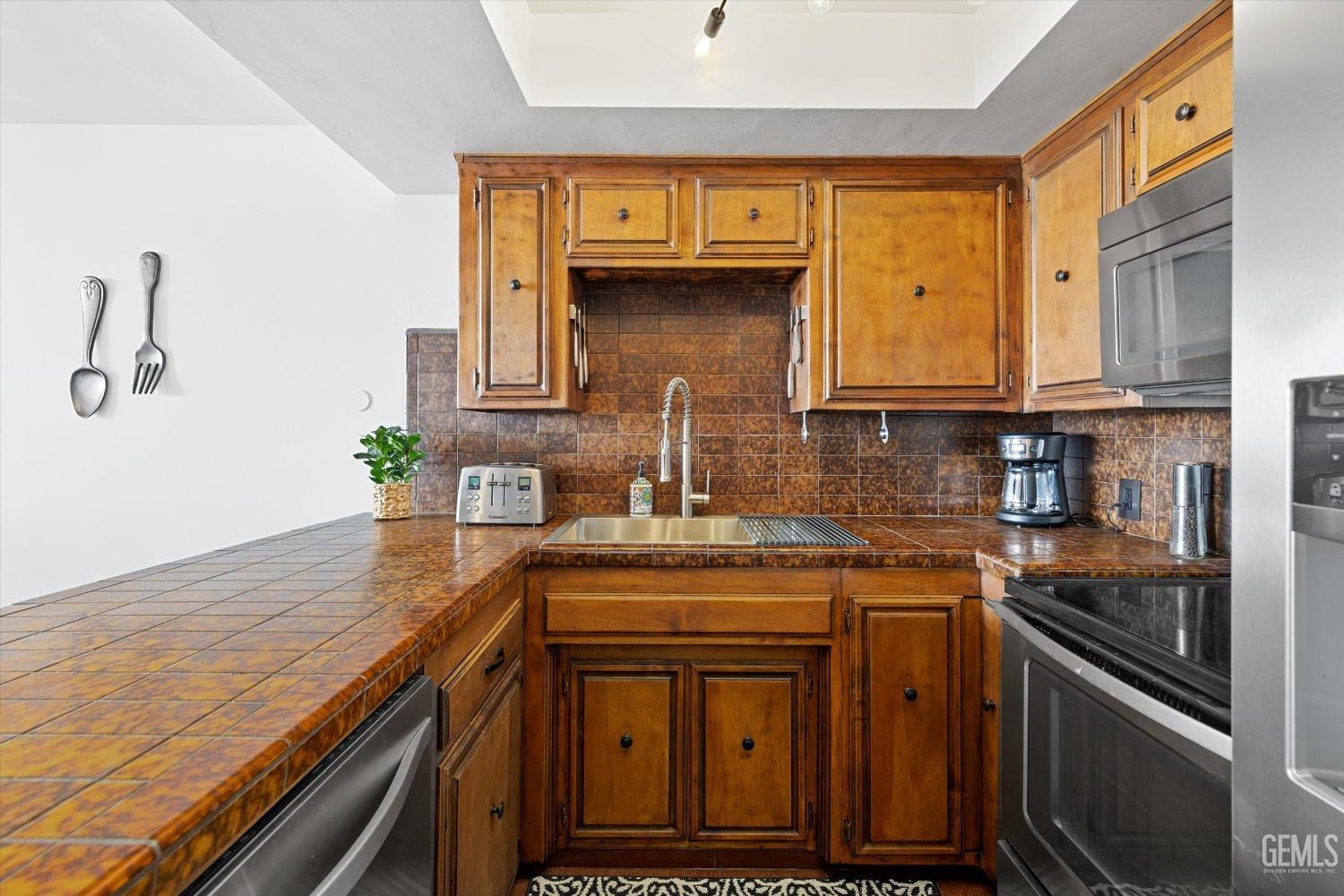 Undisclosed Address Bakersfield, CA 93306 - Photo 25 of 52 a kitchen with stainless steel appliances granite countertop a sink stove and cabinets