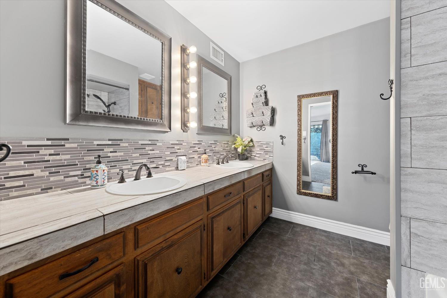 Undisclosed Address Bakersfield, CA 93306 - Photo 38 of 52 a bathroom with double vanity sinks and a mirror