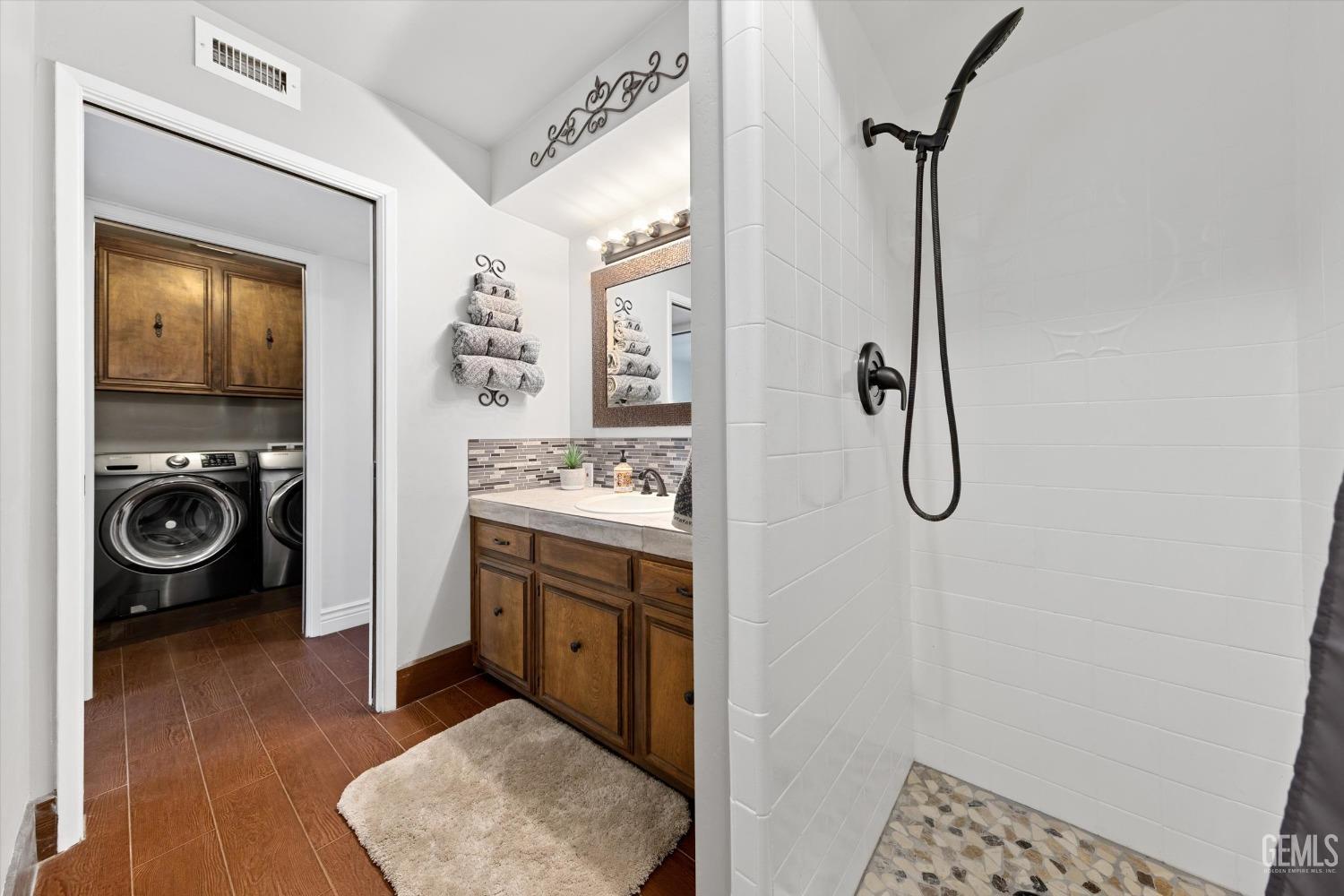 Undisclosed Address Bakersfield, CA 93306 - Photo 45 of 52 a en suite bathroom with a shower sink and a mirror