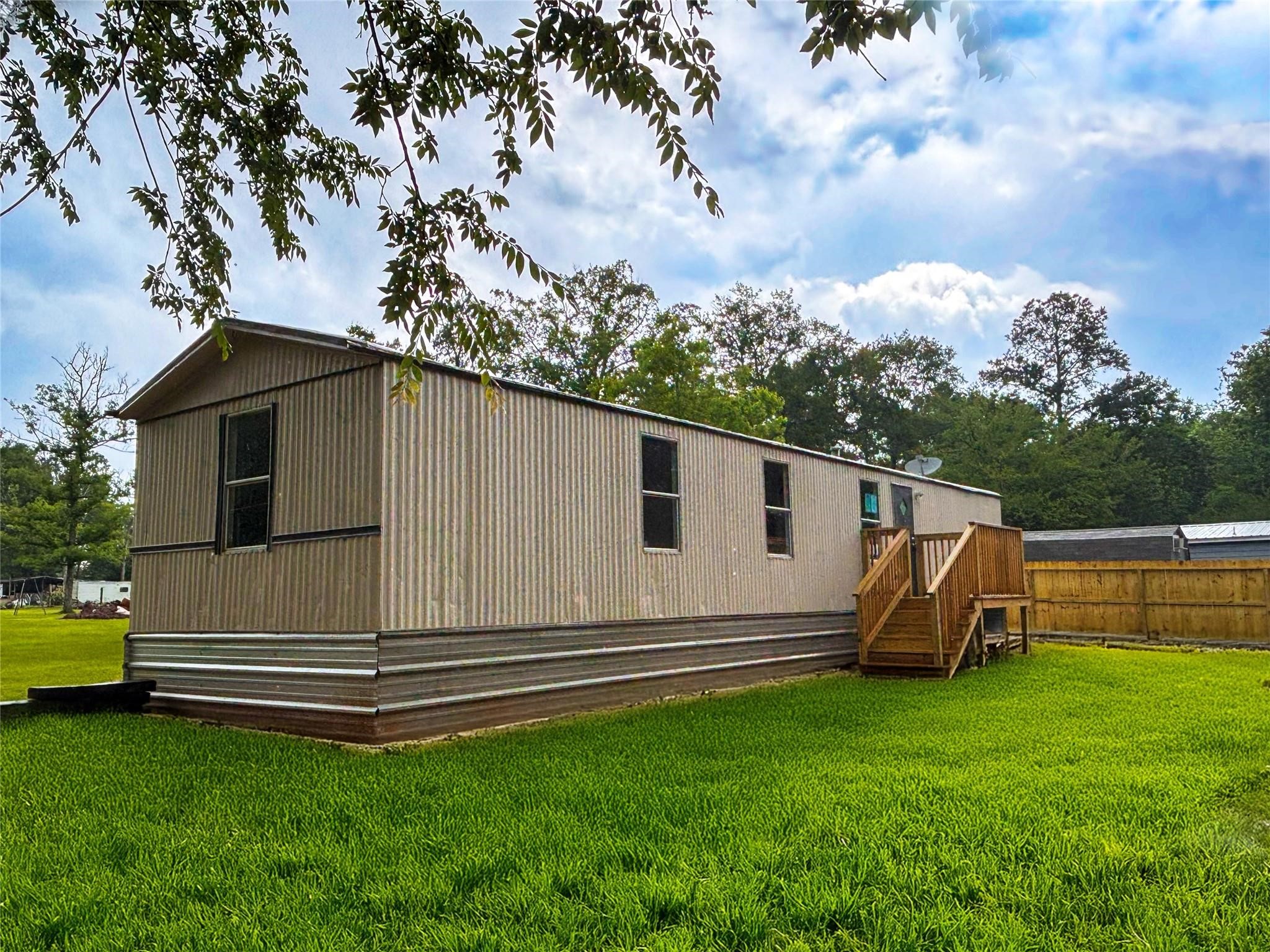 a view of backyard with barbeque grill potted plants and wooden fence