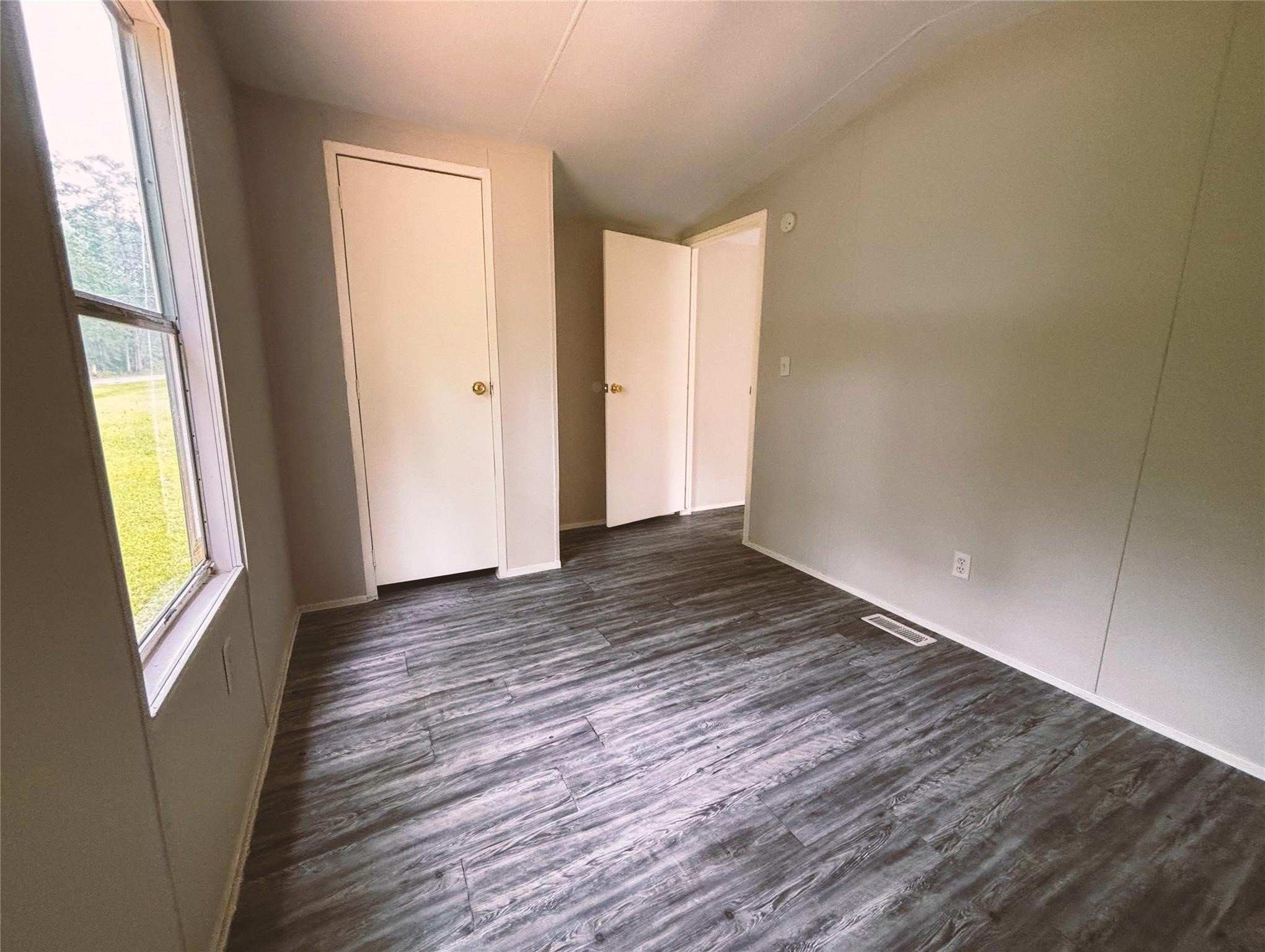 253 County Road 320 Cleveland, TX 77327 - Photo 4 of 13 a view of an empty room with wooden floor and a window