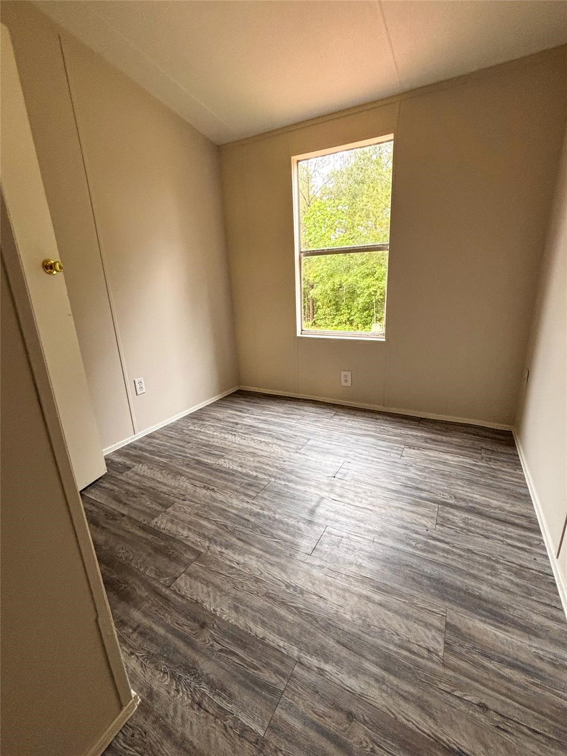 253 County Road 320 Cleveland, TX 77327 - Photo 6 of 13 an empty room with wooden floor and windows