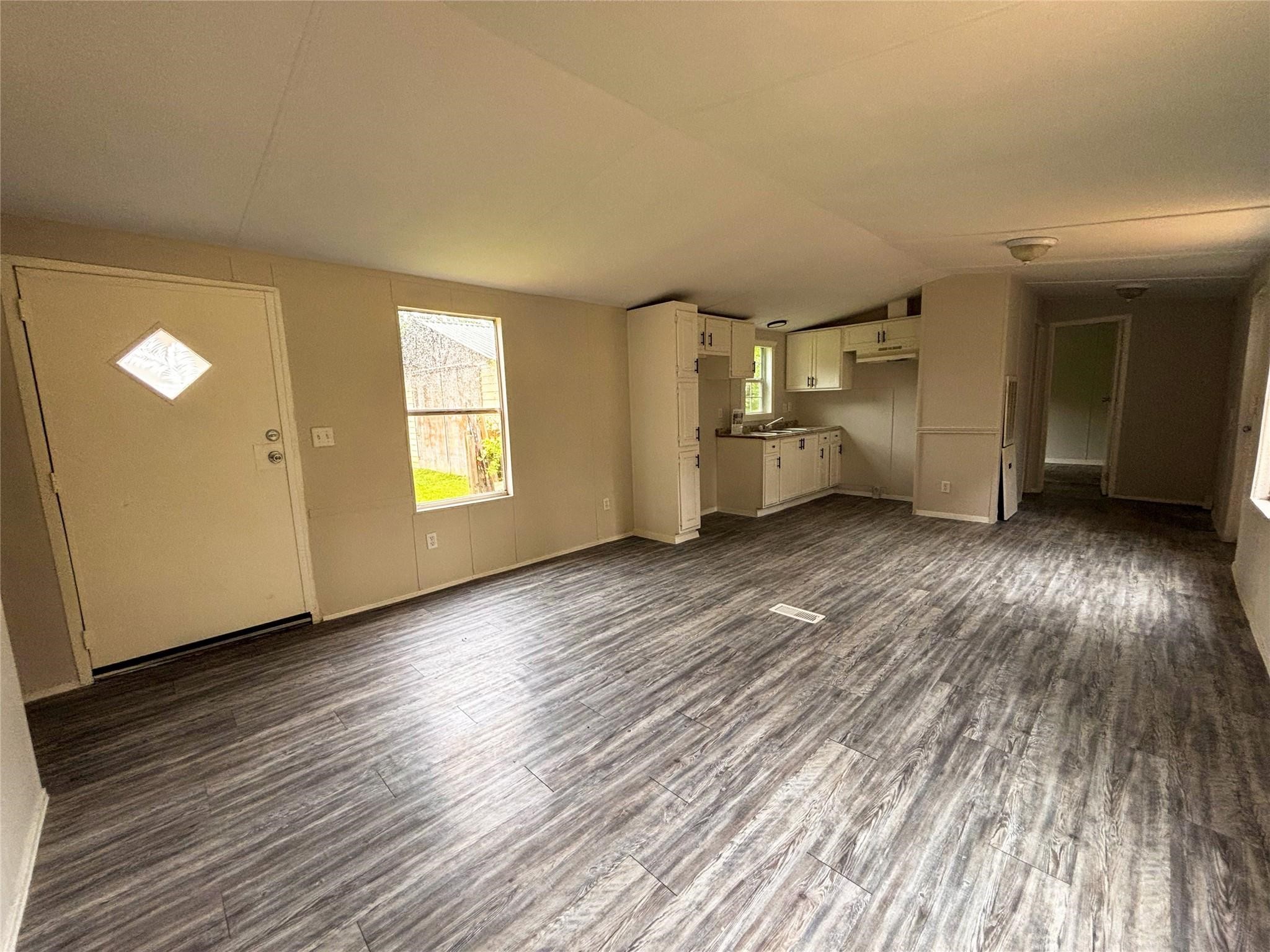 253 County Road 320 Cleveland, TX 77327 - Photo 7 of 13 an empty room with wooden floor and windows
