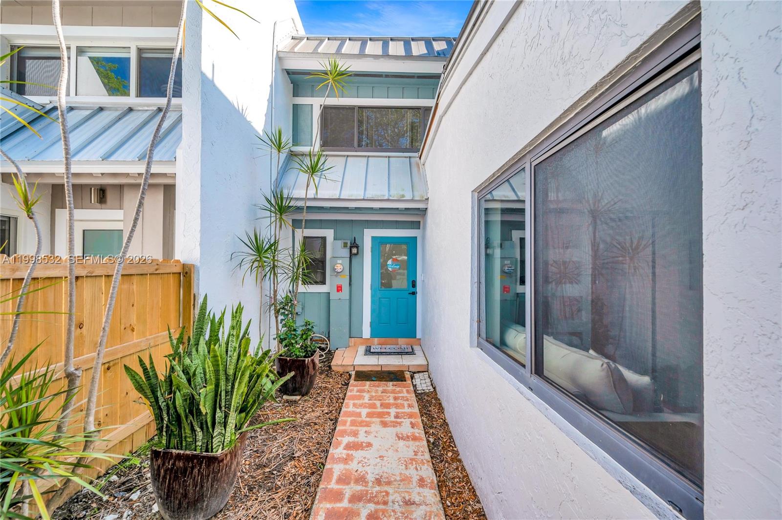 7018 Southwest 53rd Lane Miami, FL 33155 - Photo 42 of 59 a view of a brick house with a large window and potted plants