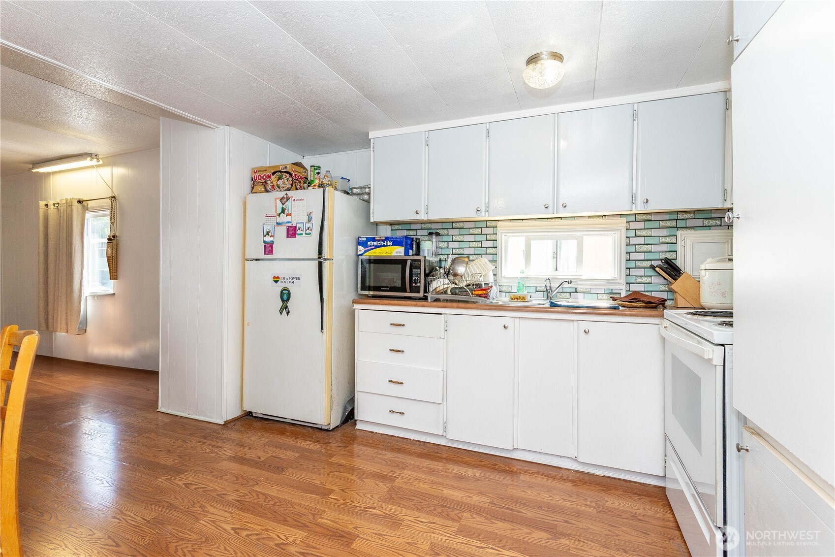 5920 200th Street Southwest, Unit 37 Lynnwood, WA 98036 - Photo 6 of 21 a kitchen with refrigerator and white cabinets