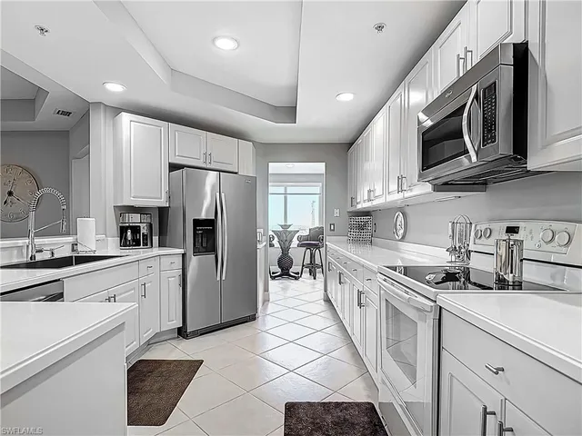 a kitchen with stainless steel appliances granite countertop a refrigerator stove microwave and sink