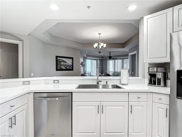 a kitchen with a sink dishwasher a stove with cabinets and couches