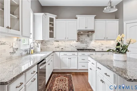 a kitchen with stainless steel appliances granite countertop a sink a stove and a granite counter tops