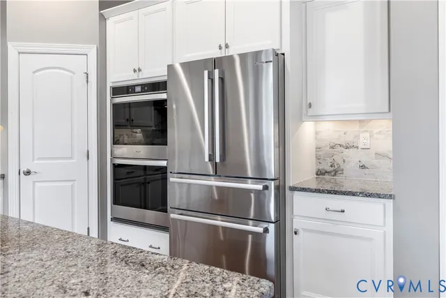 a kitchen with granite countertop a refrigerator and a stove top oven