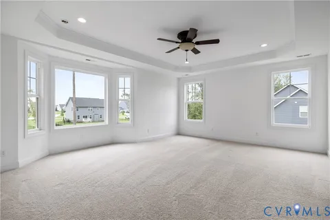 a view of an empty room with a window and a kitchen