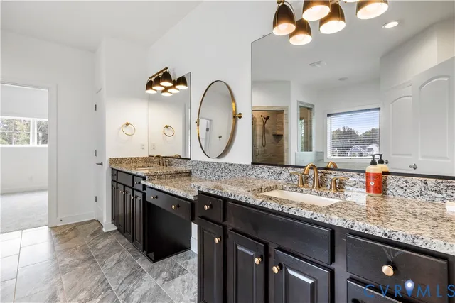 a bathroom with a granite countertop double vanity sink and a mirror