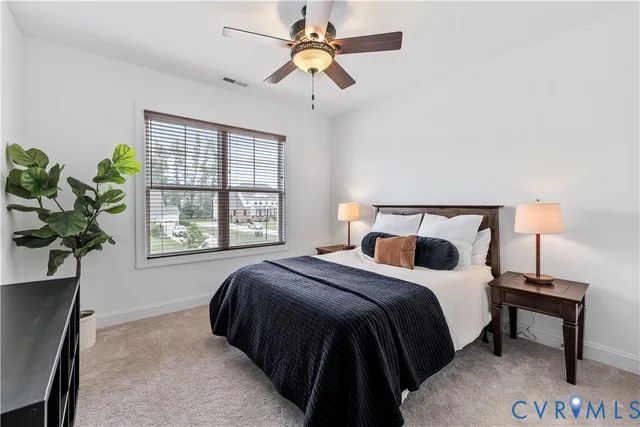 a bedroom with a bed potted plant on a dresser and a chandelier