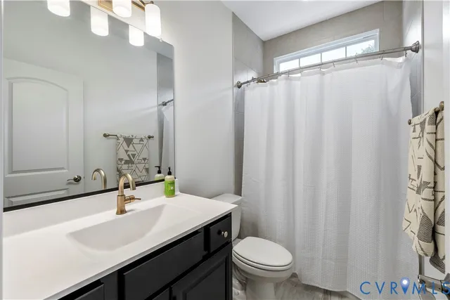 a bathroom with a sink a toilet a mirror and shower curtain