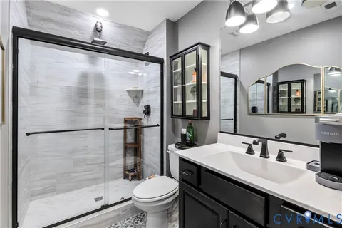 a bathroom with a granite countertop sink mirror toilet and shower