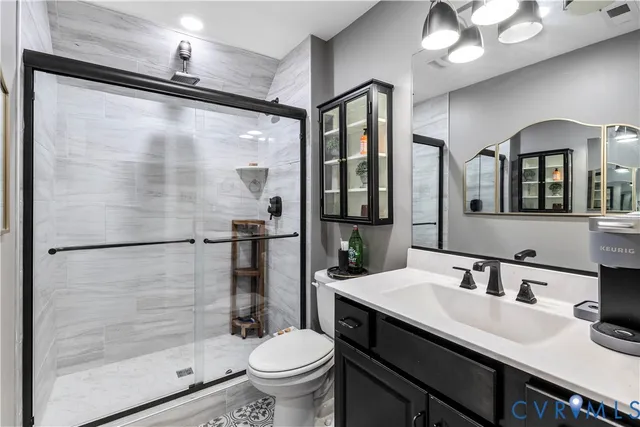 a bathroom with a granite countertop sink mirror toilet and shower