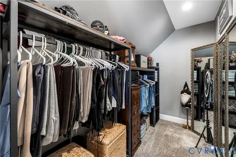 a view of walk in closet with clothes and shoes
