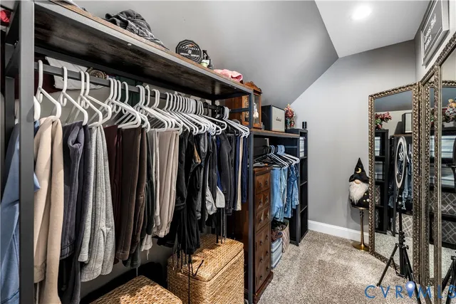 a view of walk in closet with clothes and shoes